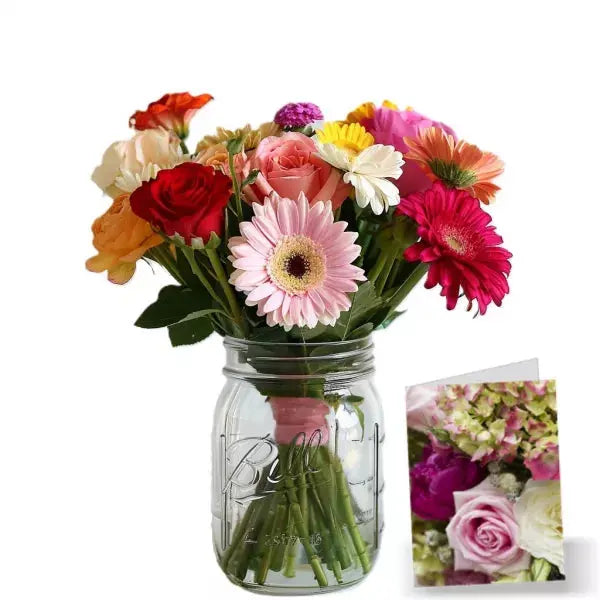 A colorful bouquet of mixed flowers in a mason jar, white background with a small flower card.