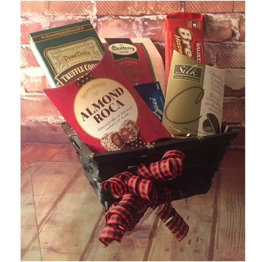 Gift basket with assorted treats including Almond Roca and chocolate chip cookies, adorned with a red and black ribbon.