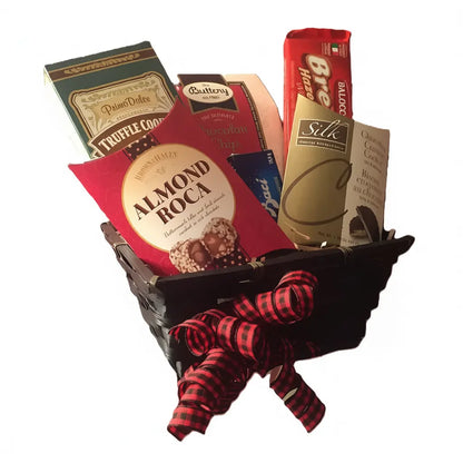 Gift basket with assorted items including a box of Almond Roca, a bag of Silk chocolate, and a box of truffle cookies.