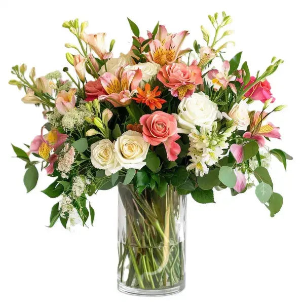 A vibrant bouquet of mixed flowers in a clear glass vase.